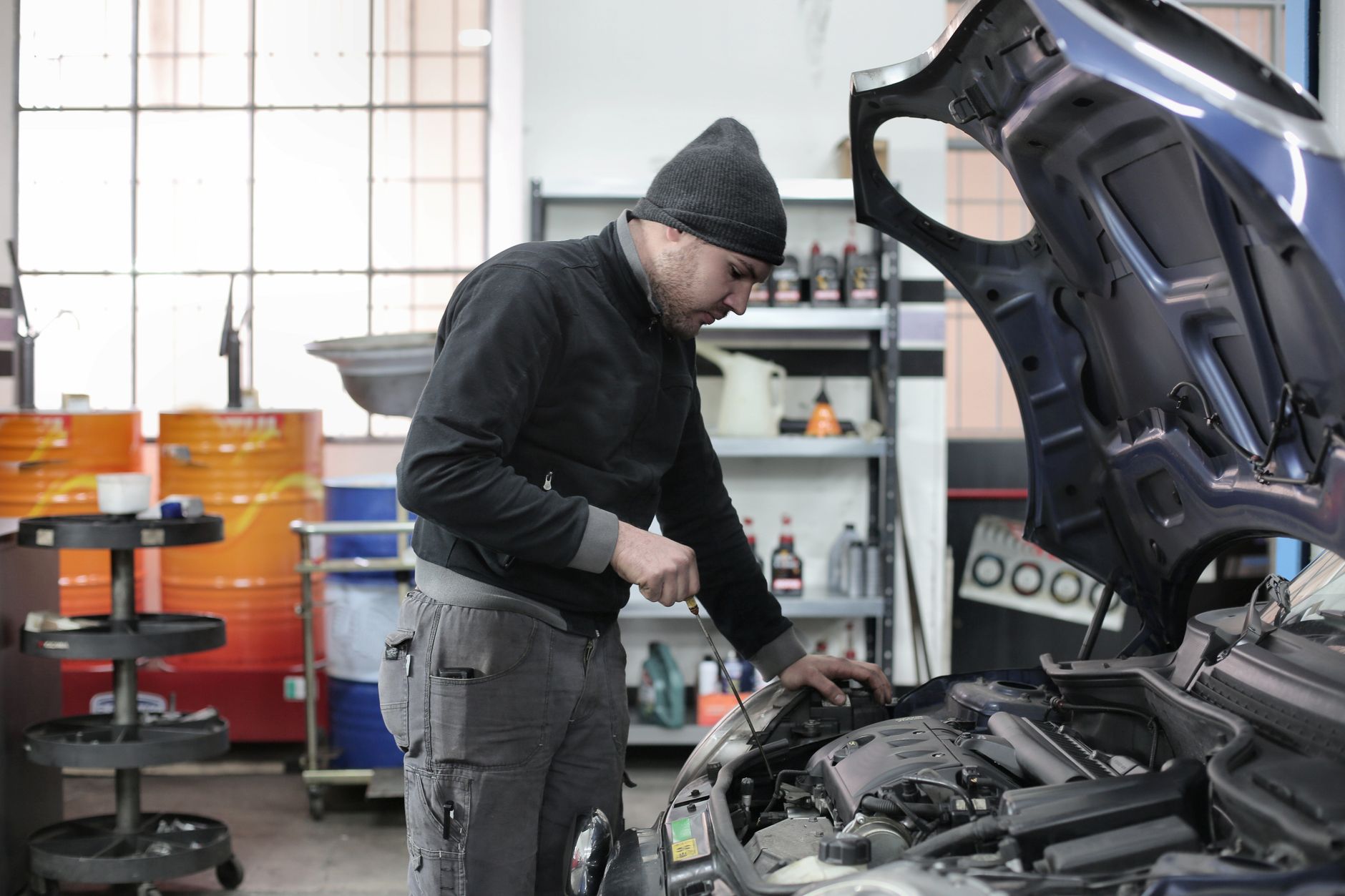 Mechanic repairing a car, a common reason for a $300 same-day cash loan in Canada