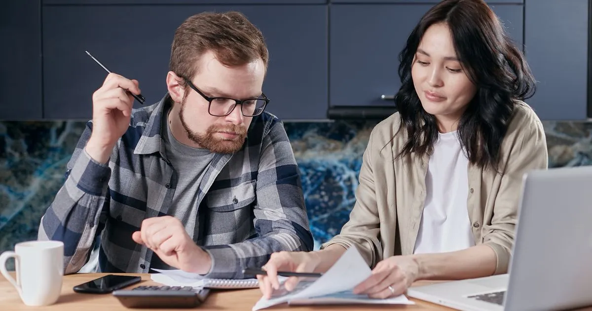 Couple totalling bills before applying for a loan today
