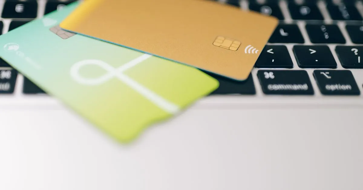 Credit cards on a laptop keyboard while comparing cash advance fees online