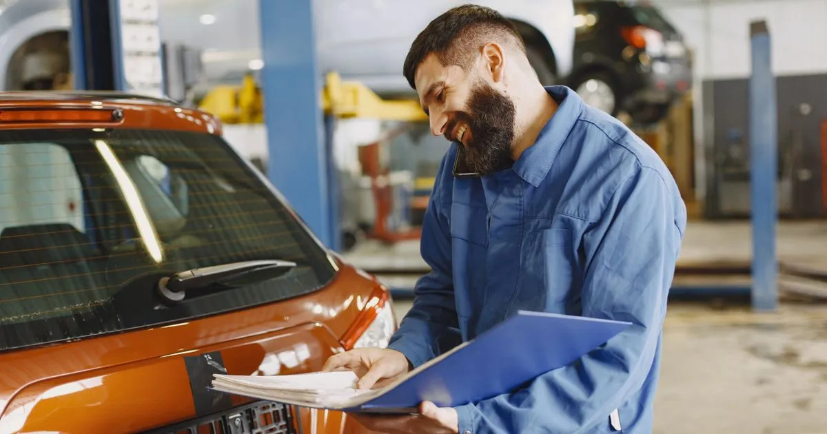 Mechanic reviewing a repair estimate - a common reason for emergency cash loans