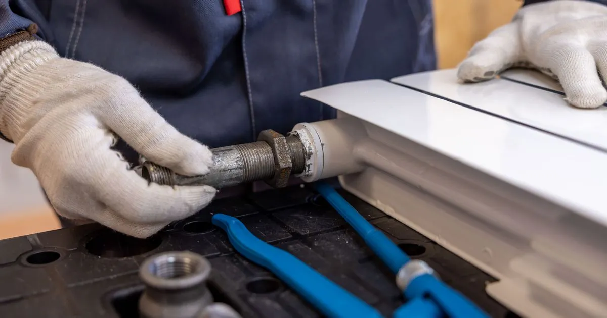 Plumber reassembling a radiator pipe - get an itemized estimate before borrowing for a repair