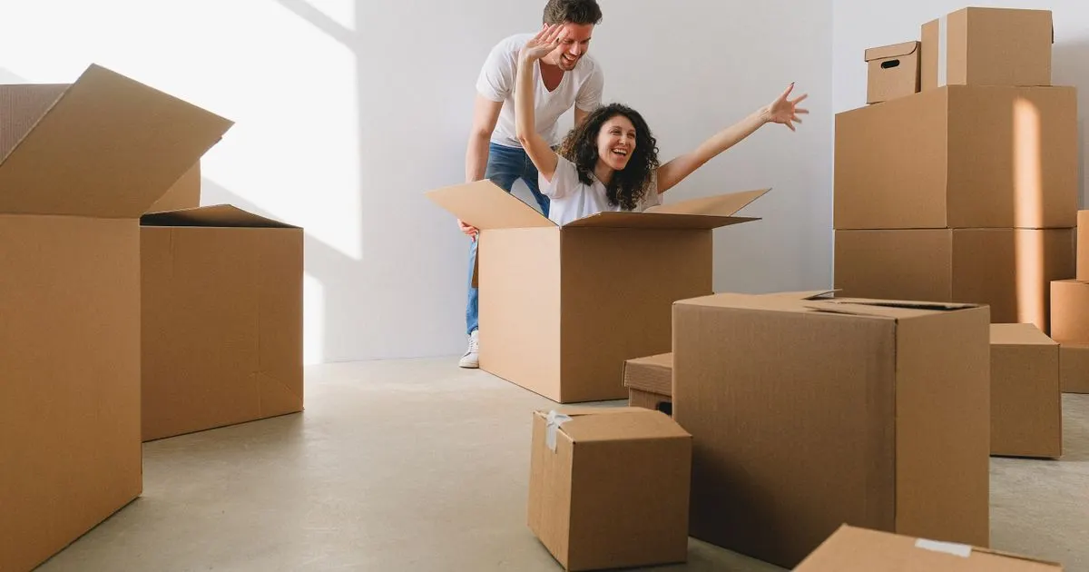 Couple carrying boxes on moving day - moving expense loans in Canada