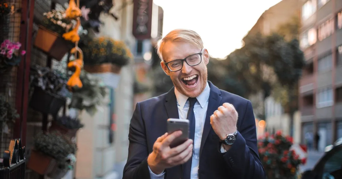 Man celebrating a rapid loans approval notification on his phone